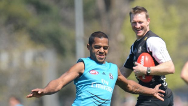 Collingwood assistant coach Nathan Buckley shares a laugh with Leon Davis at training.