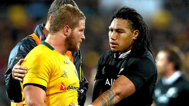 Ma'a Nonu of the All Blacks checks on the condition of James Slipper.