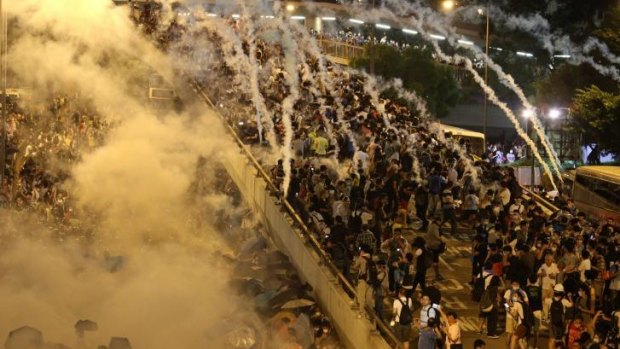 Rapid response: Police fire tear-gas as crowds of demonstrators grow. 