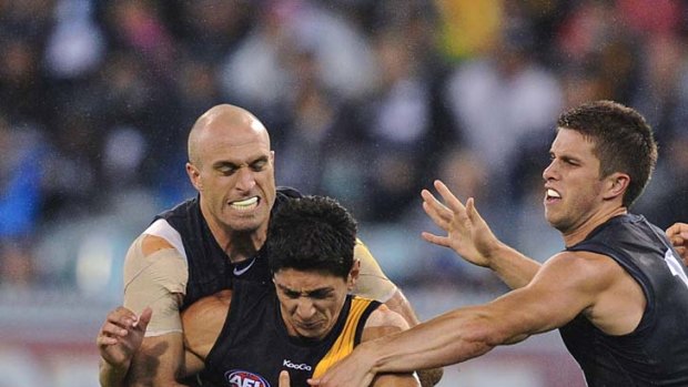 Chris Judd applies a firm tackle on Richmond's Robin Nahas in round one, as Marc Murphy prepares to lend a hand.