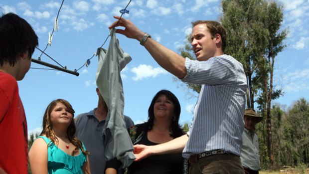 Prince William with Colin and Michelle French, their children Vanessa and Darcy and the shirt that survived the fire.