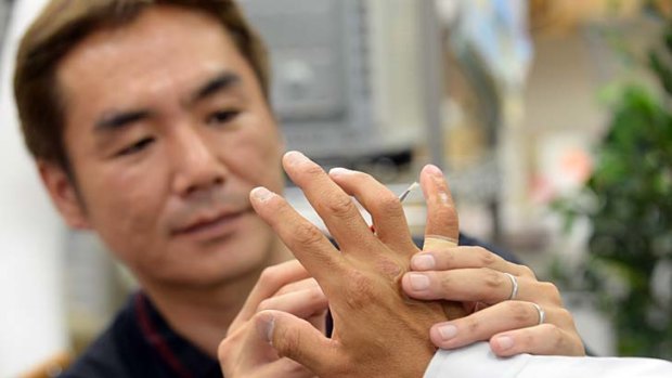 Prosthetics specialist: Shintaro Hayashi checks the silicone-made finger of a former yakuza gangster.