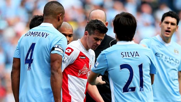 Angry ... Joey Barton of QPR looks down after kicking Sergio Aguero.