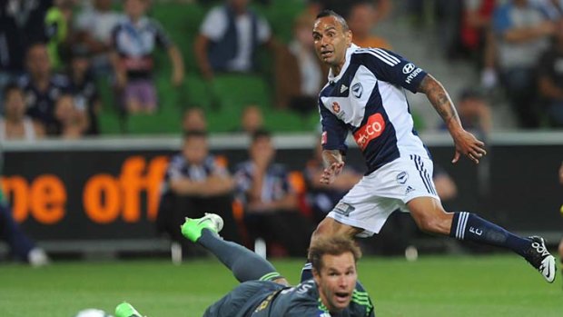 Out of reach: Victory's Archie Thompson gets the ball past Phoenix's Mark Paston but not into the goal. It didn't matter, Victory was too strong.