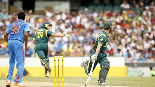 India's Ravichandran Ashwin (left) and Australia's Matthew Wade (right) watch as David Hussey (centre) fends off a return with his hand during their one-day international cricket match at the Sydney Cricket Ground.