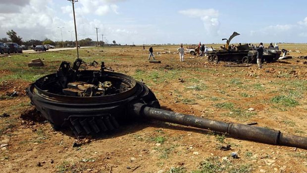 The turret of a tank belonging to forces loyal to Libyan leader Muammar Gaddafi lies on the ground after an air strike by coalition forces, along a road between Benghazi and Ajdabiyah.