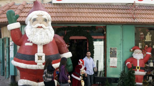 Palestinian women are confronted by a giant Santa in the biblical West Bank town of Bethlehem.