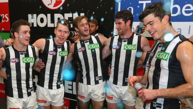 Jackson Ramsay (left) and Tom Langdon (second from left) sing the song after the Pies defeated Carlton on Friday night.