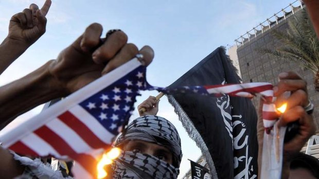 Protesters burn a replica of the US flag during a demonstration against the capture of an al-Qaeda suspect Abu Anas al-Liby.