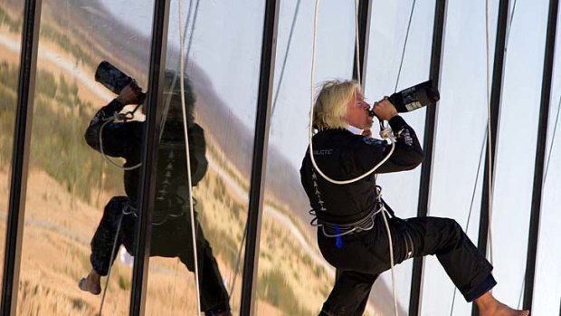 British billionaire Richard Branson rappelled from a balcony, shook up a bottle of champagne and took a swig while christening the world?s first built-from-scratch commercial spaceport.