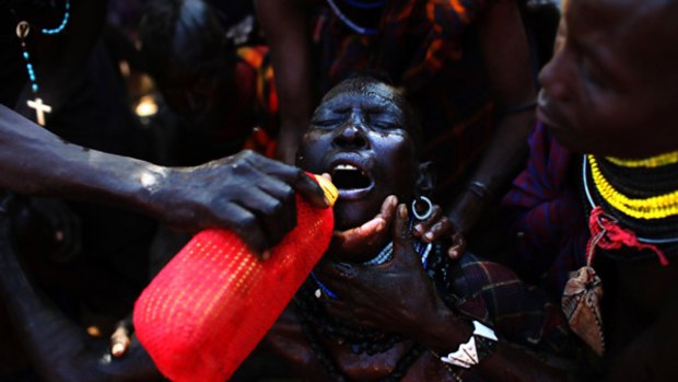 A villager is forced to drink to water in Lokori, Kenya.