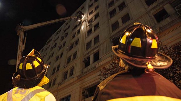 Firefighters inspect a building in downtown Santiago after the earthquake on Sunday.