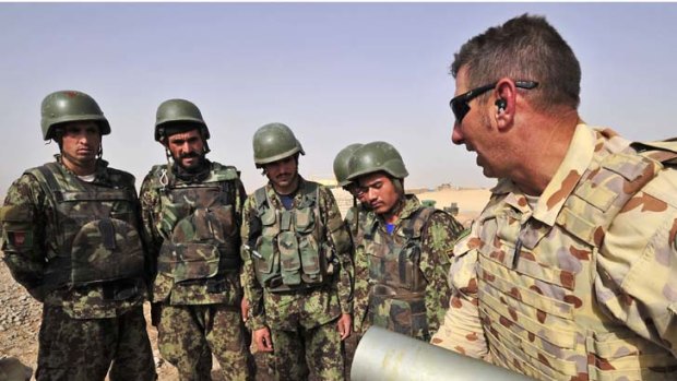 Gun mentor ... Warrant Officer Class Two David Kristan demonstrates charge bag and shell handling to Afghan artillery soldiers at Multi-National Base Tarin Kowt in Afghanistan.