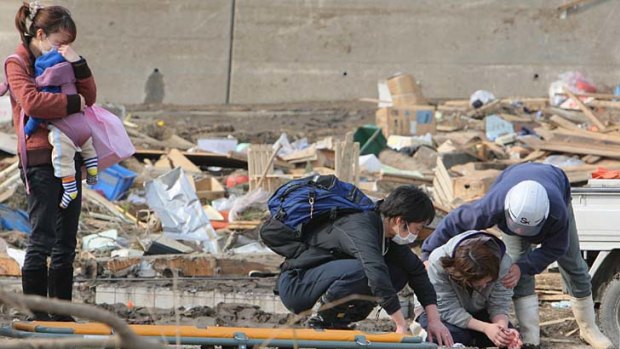 Australian authorities are working to locate missing citizens believed to have been in the areas devastated by the earthquake and tsunami, while locals carrying stretchers search for survivors in Miyako, northern Japan.