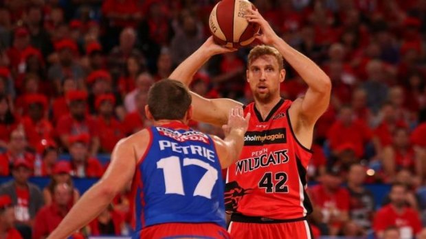 Shawn Redhage of the Wildcats looks to pass over Anthony Petrie of the 36ers.