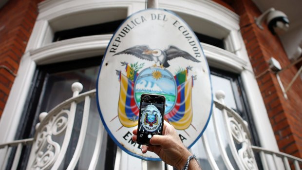 A man photographs the sign on the balcony of the Ecuadorian embassy in London on Thursday. 