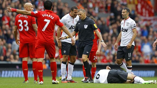 Seeing Red ... Manchester United's Jonny Evans lays on the ground after a dubious tackle from Liverpool's Jonjo Shelvey.