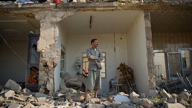 Total destruction ... Yousef Hayeni stands in front of the remains of his house following the air strike.
