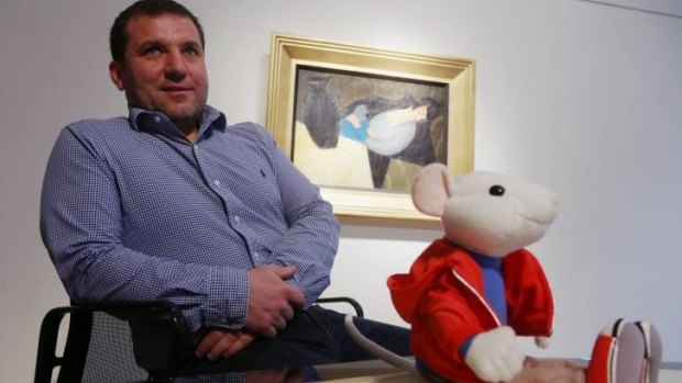 Chance find: Hungarian art historian Gergely Barki with a plush figure of Stuart Little in front of the painting by Hungarian artist Robert Bereny, <i>Sleeping Lady with Black Vase</i>.