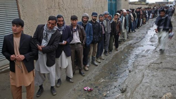 Men queue to cast their votes at a polling station in Kabul.