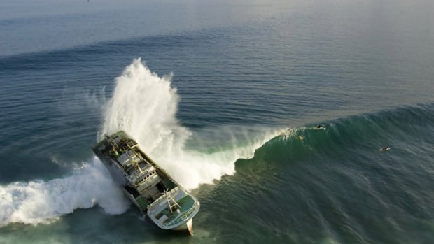 On the rocks: Balinese environmentalists and international surfers are fearful of pollution to come   after a farcical salvage attempt failed on the famous Padang Padang beach. 