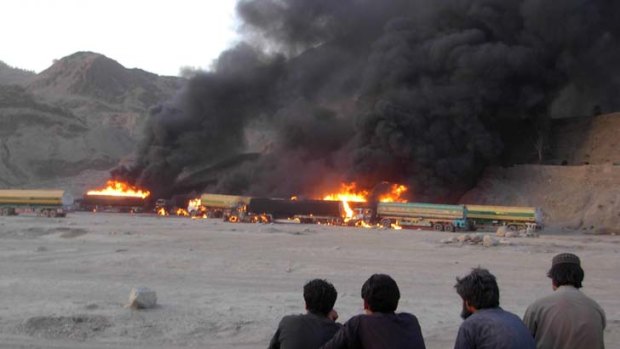 Pakistani drivers watch NATO oil tankers burning after a bomb blast in the troubled Khyber tribal region near the Afghan border. There were no casualties.