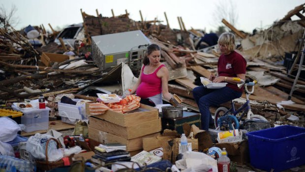 Standy Stewart and her pregnant daughter-in-law Robyn Rojas have their dinner at what left of their tornado devastated home on May 21, 2013 in Moore, Oklahoma.