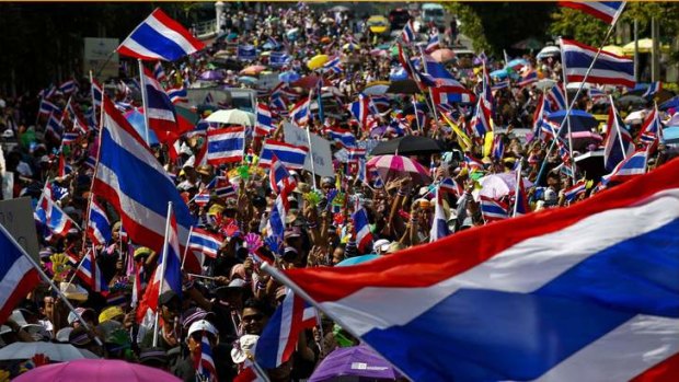 Anti-government protesters wave Thai national flags as they march toward the Labour Ministry in Bangkok.