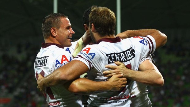 Sea Eagles players celebrate a try by Michael Robertson.