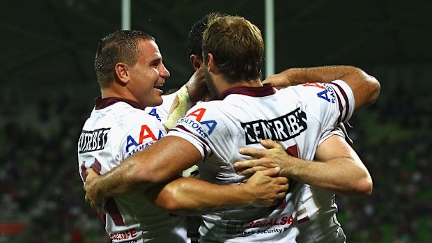 Sea Eagles players celebrate a try by Michael Robertson.