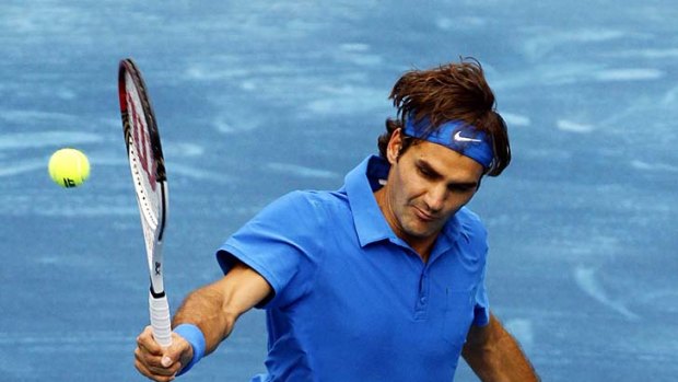 Roger Federer plays a backhand to Janko Tipsarevic.