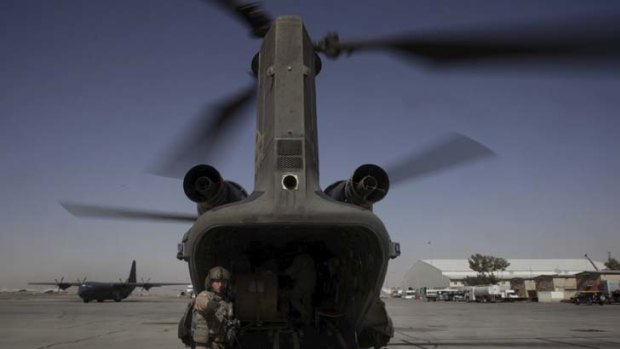 An air crewman from an Australian Army chinook, based at Kandahar Airfield, organises the pick-up of a load during a resupply mission to a forward operating base in Afghanistan.