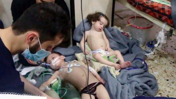 An image made from video released by the Syrian Civil Defense White Helmets, shows medical workers treating toddlers following an alleged poison gas attack in the opposition-held town of Douma, in eastern Ghouta, near Damascus, Syria. 