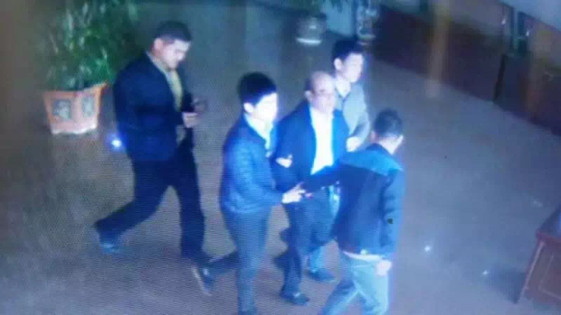 Chinese social media has been widely sharing a picture of a man resembling Mr Guo being led through an airport by what appear to be plain-clothes police. 