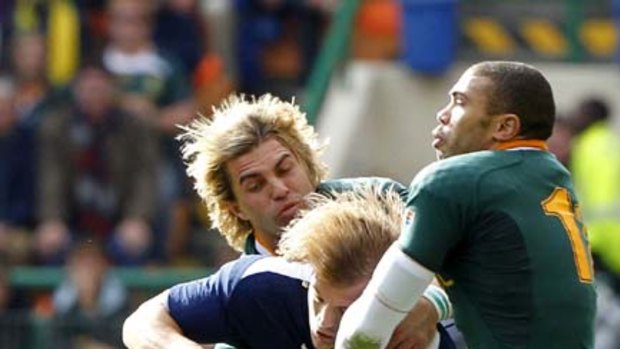 South Africa's Wynand Olivier (L) and Brayan Habana (R) tackle France's Aurelien Rougerie.