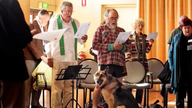 All creatures great and small: Father Greg Reynolds leads Mass at the Inclusive Catholics service in South Yarra, where one first-time visitor brought his dog along.