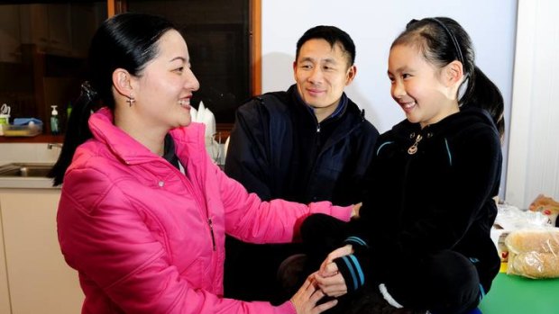 L-R: Ling Lin, 32, Qiang Yu, 42, and daughter, Qi Yun Yu, 7, at their family home in Isaacs.