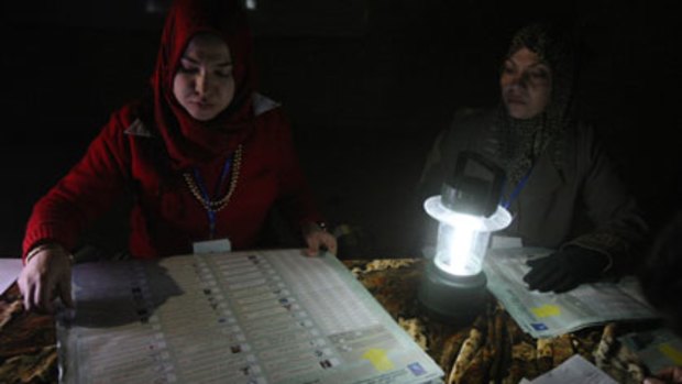 Undeterred by darkness and danger ... Iraqi election officials count votes using a rechargeable battery lamp at a polling station in Sadr City.