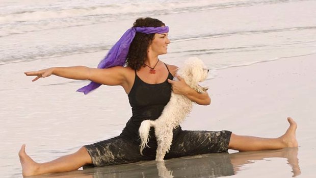 Doga instructor Suzi Teitelman and dog Roxy  in a straddle pose at Ponte Vedra Beach, Florida.