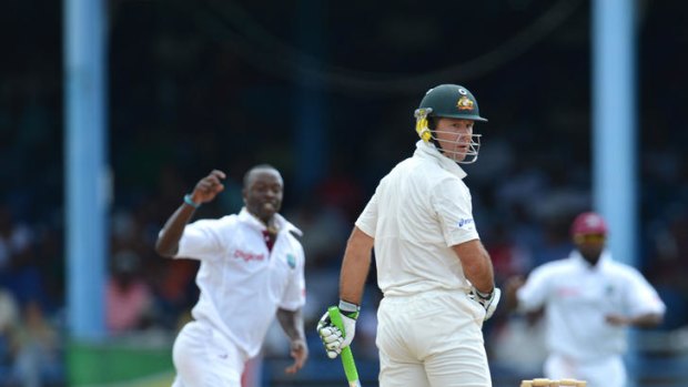 Ricky Ponting looks back to see his shot caught out by Darren Sammy as bowler Kemar Roach celebrates.