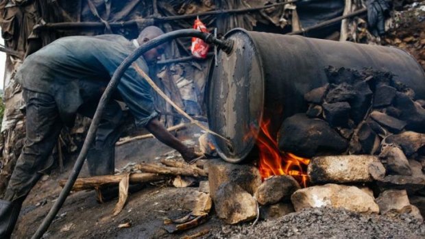 A man stoking the fire of a 'chang'aa' distillery in the Mathare slum of Nairobi. The illegal brew is now thought responsible for 80 deaths.