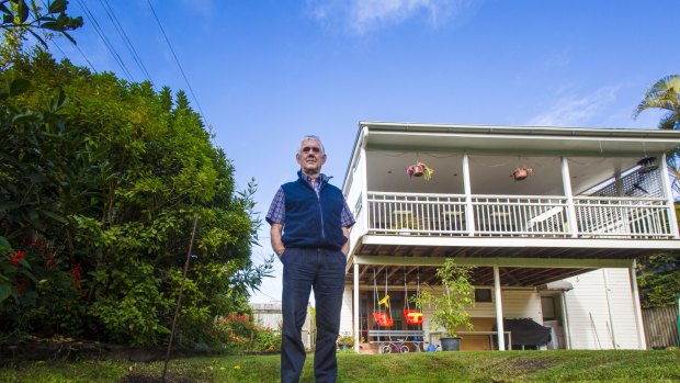 Gerry Winter stands next to a sinkhole in his backyard in the Brisbane suburb of Wooloowin that he claims was caused by the Airport Link tunnels