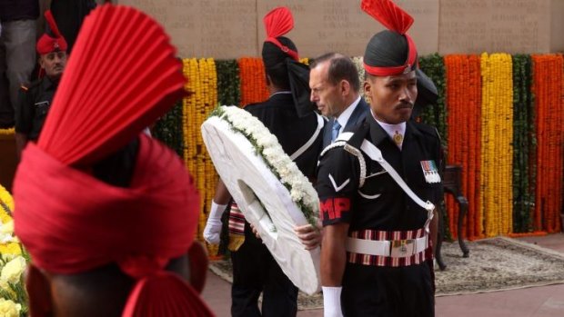 Making an impression overseas: Tony Abbott lays a wreath in Delhi on Friday.