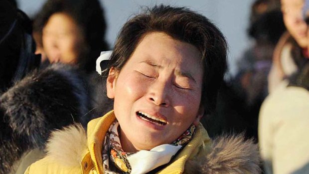 A mother and her son cry as they mourn the death of North Korean leader Kim Jong-il at a square on Mansu Hill in Pyongyang.