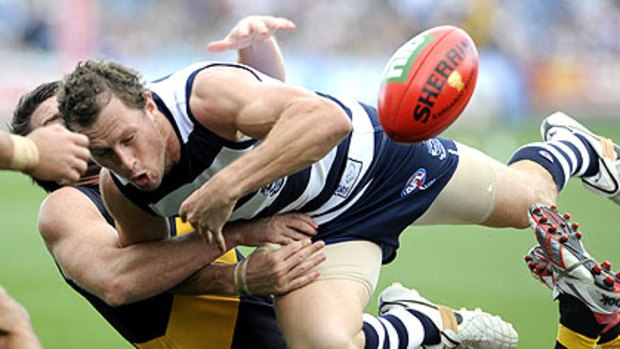 Geelong's James Kelly loses the ball as he tries to crash through a Chris Newman tackle at Skilled Stadium yesterday.