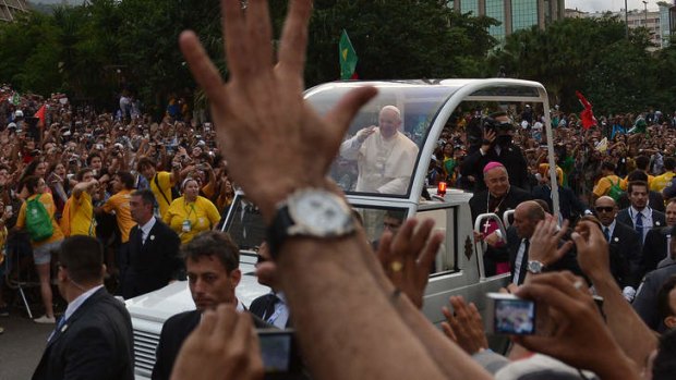 Pope Francis waves at faithfuls from the popemobile on his way to the Guanabara Palace after his arrival in Rio de Janeiro.