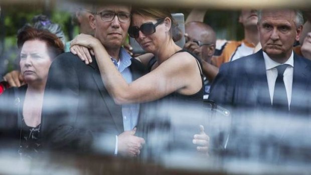 Relatives of MH17 victims embrace as they watch hearses carrying what could be the remains of their  loved ones.