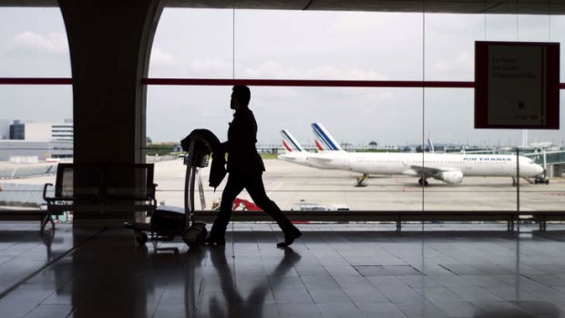 Grounded: A passenger totes his bags at Roissy Charles de Gaulle international airport on Tuesday, when hundreds of flights were cancelled.