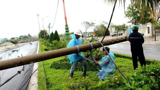 Workers repair a fallen electricity pole in the central province of Phu Yen, Vietnam.