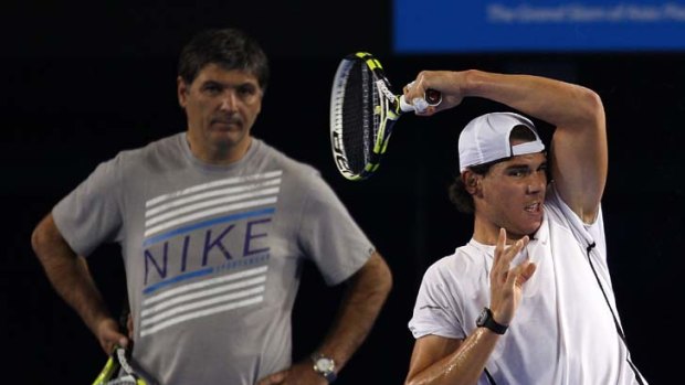 Somebody watching over him ... Rafael Nadal plays a forehand as his uncle and coach Toni Nadal takes notes.